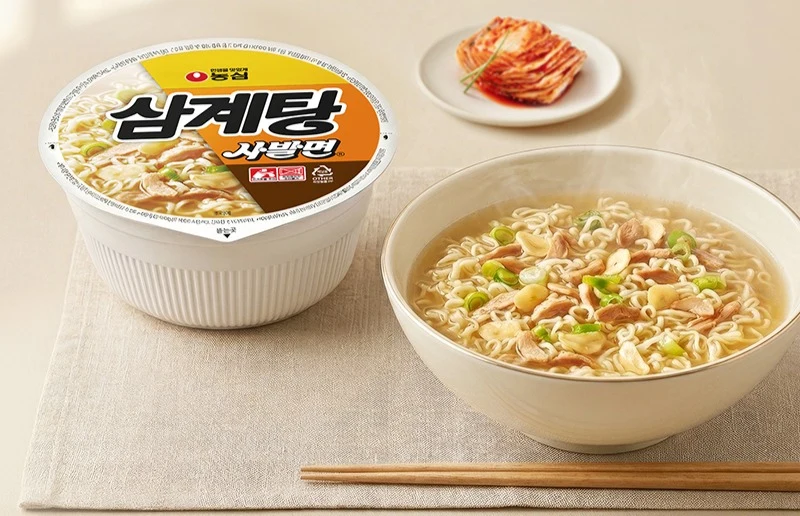 그릇에 옮겨 담은 삼계탕 사발면과 김치 한 접시