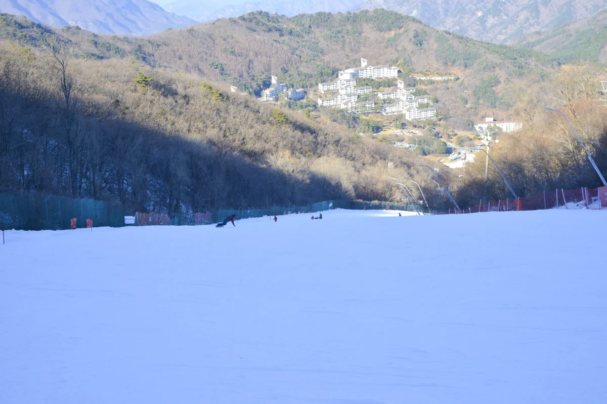 산 아래 리조트 건물이 보이는 슬로프